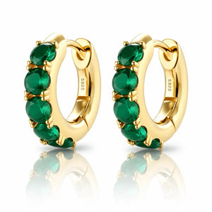 Gold hoop earrings with green gemstones on a white background