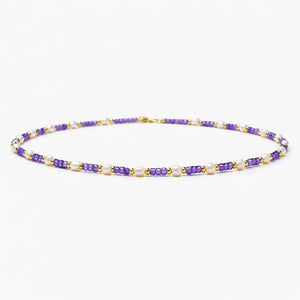 Violet pearl beaded necklace with gold accents on white background