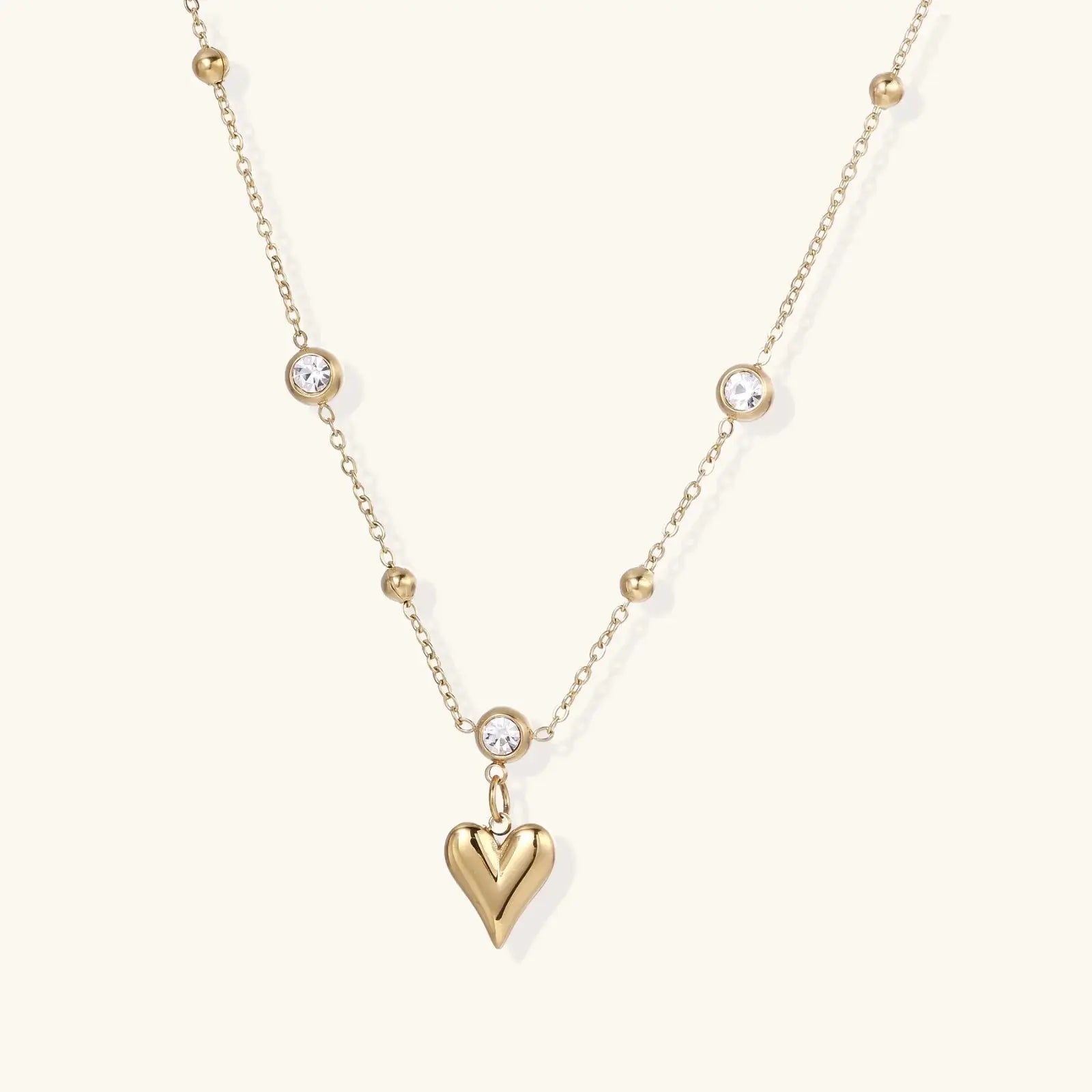 Gold necklace with a heart pendant on a white background