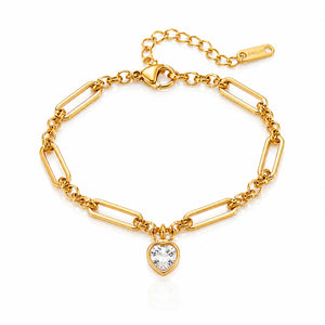 A gold paperclip chain bracelet with a heart-shaped clear crystal pendant, displayed on a clean white background.