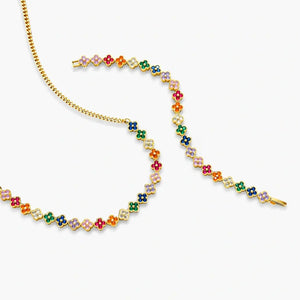 Gold bracelet and necklace with colorful enamel flower charms on white background