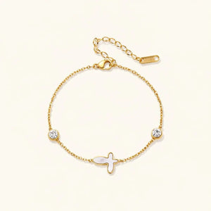Gold bracelet with fish charm and crystals on a white background