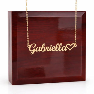 Gold necklace with 'Gabriella' and a heart pendant on a wooden box