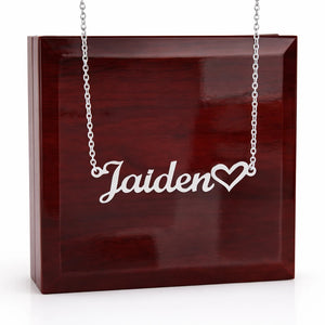 Silver necklace with 'Jaiden' and a heart pendant on a wooden box