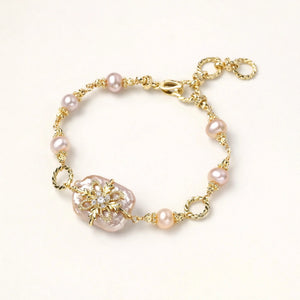 Gold bracelet with pink pearls on a white background