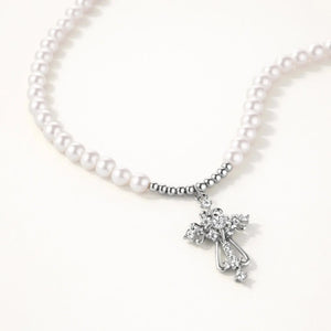 Pearl beaded necklace with silver cross pendant on white background