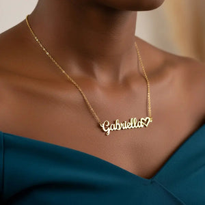 Gold necklace with 'Gabriella' pendant on a person wearing a blue top.
