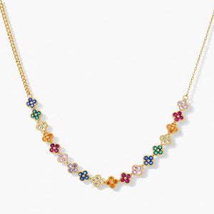 Gold chain necklace with colorful enamel flower charms on white background