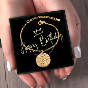 Hand holding a gold star map bracelet in a black gift box with Happy Birthday message