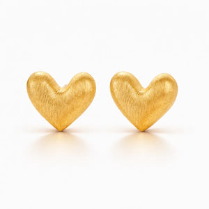 Pair of gold heart-shaped earrings on a white background