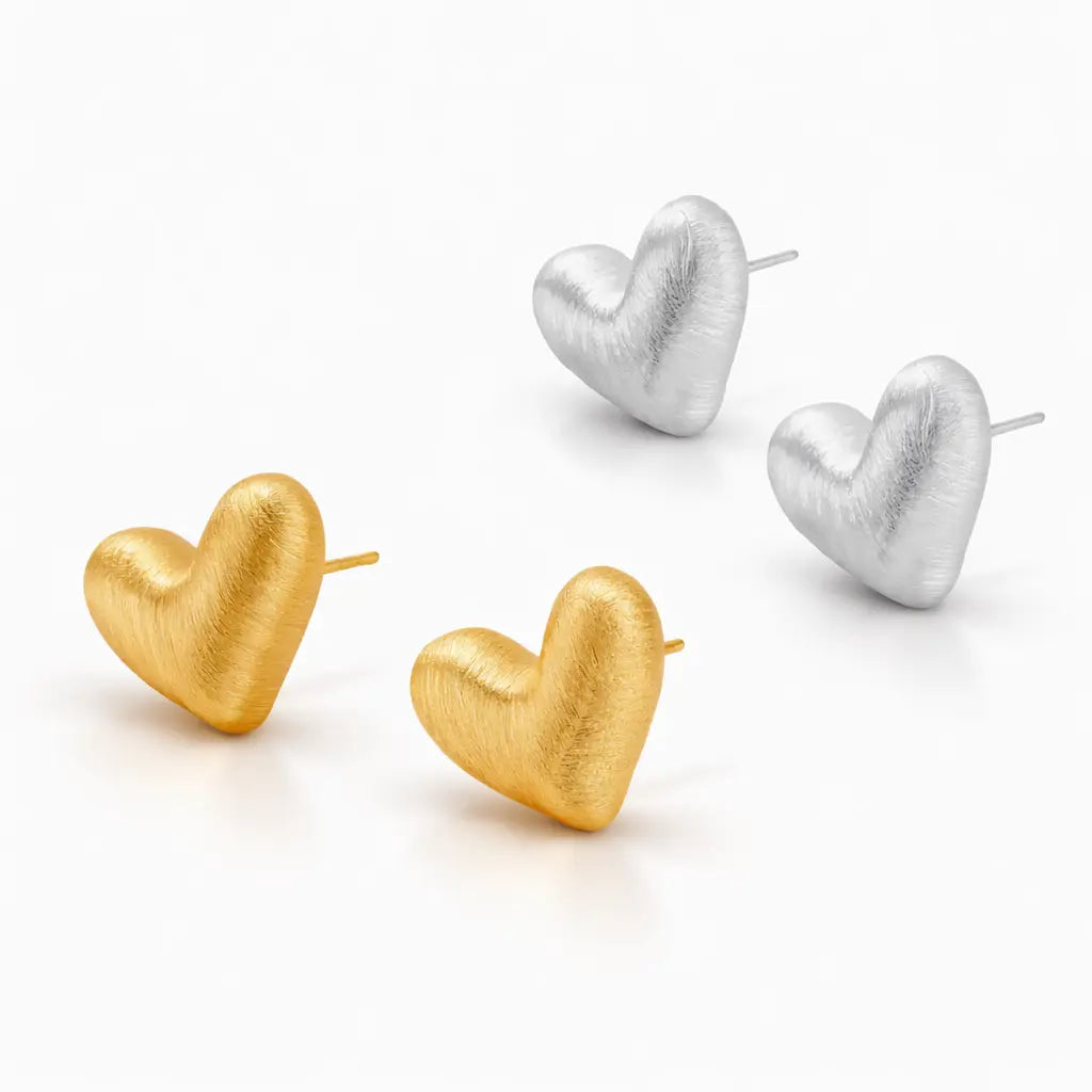 Gold and silver heart-shaped earrings on a white background