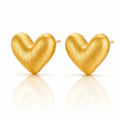 A pair of textured gold heart-shaped stud earrings on a clean white background with soft reflections below.