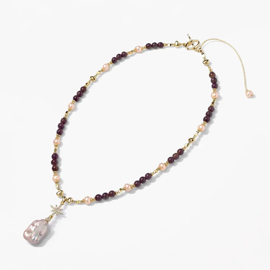 Gold amethyst and pearl necklace with a large baroque pearl pendant on white background