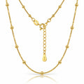 A gold beaded chain necklace with a matching extender chain and clasp, displayed on a clean white background with a subtle reflection.