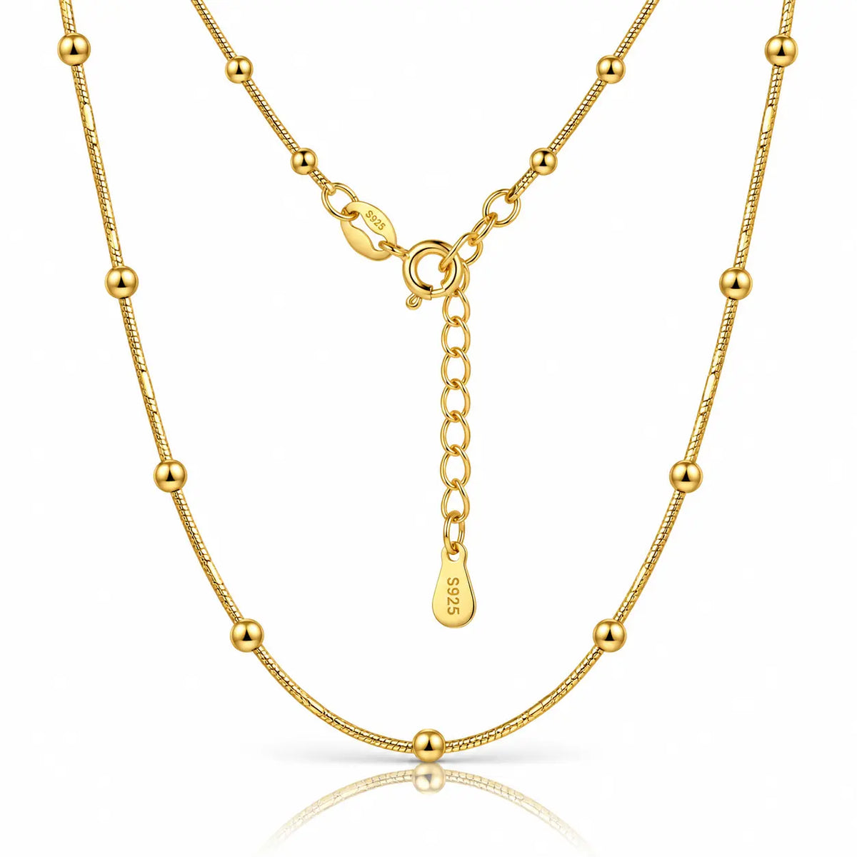 A gold beaded chain necklace with a matching extender chain and clasp, displayed on a clean white background with a subtle reflection.