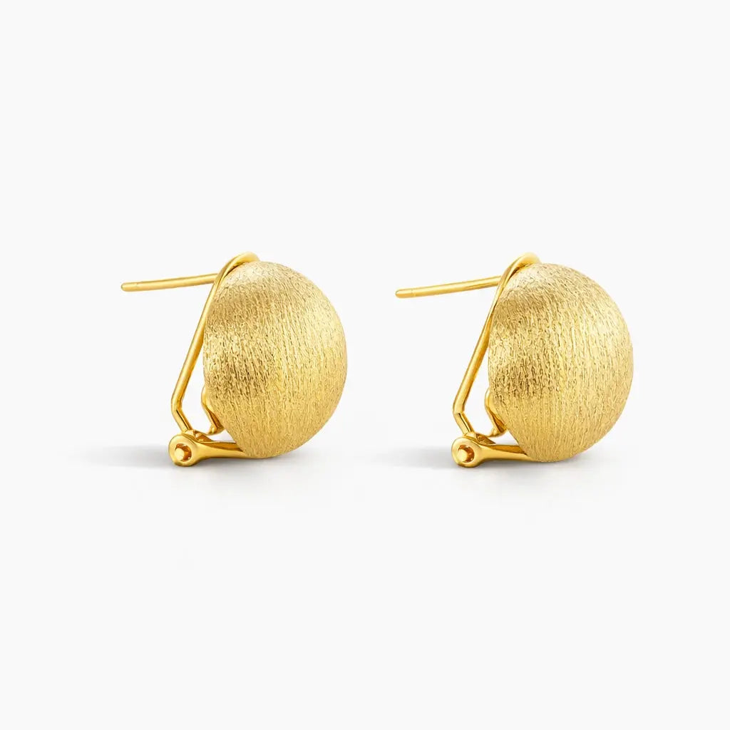 Pair of brushed 24K gold dome stud earrings with clip backs on white background