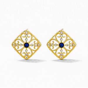 Gold square stud earrings with blue center stone and crystal accents on white background