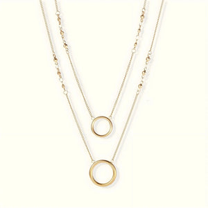 Two gold necklaces with circular pendants on a white background