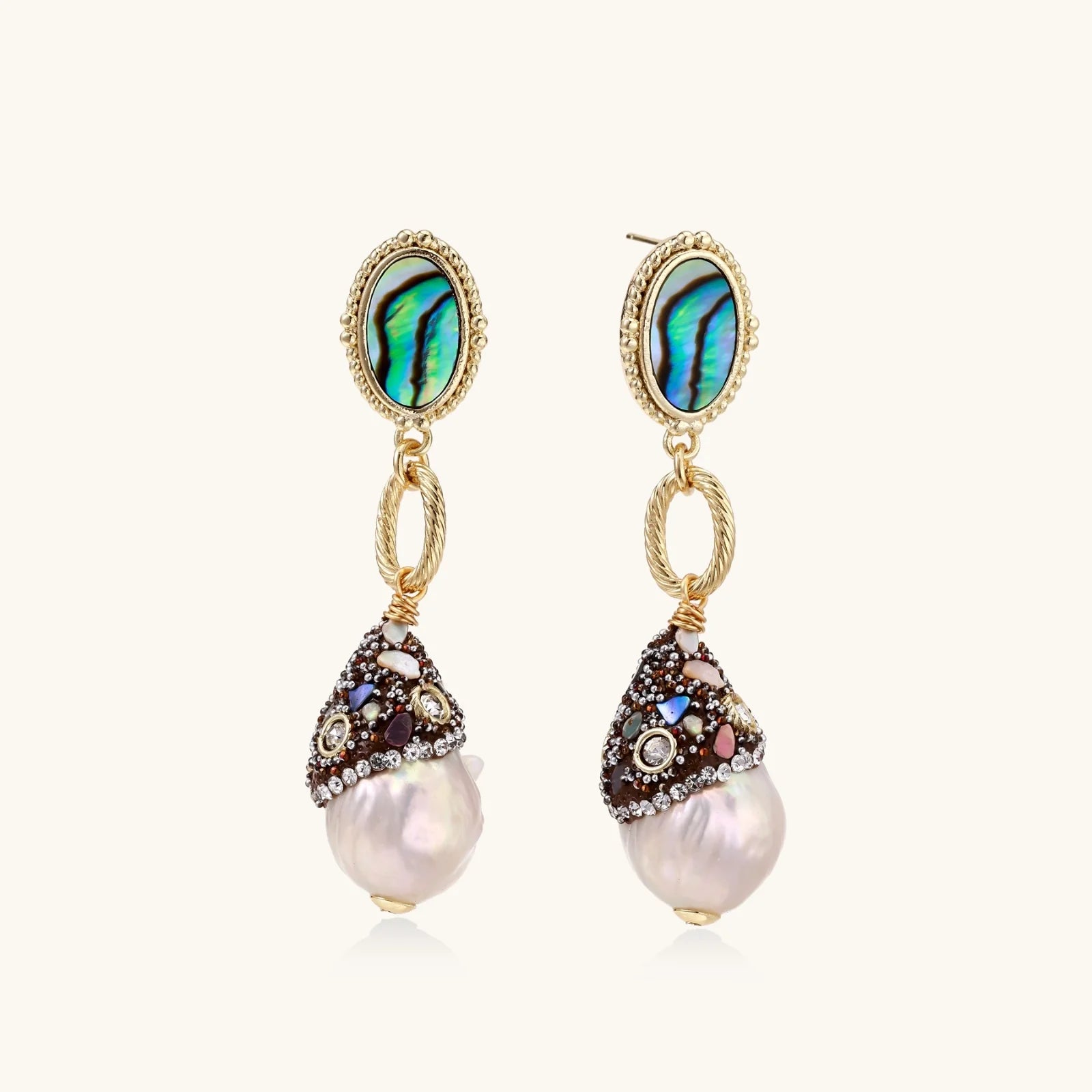 Pair of earrings with pearl drops and gemstone accents on a white background