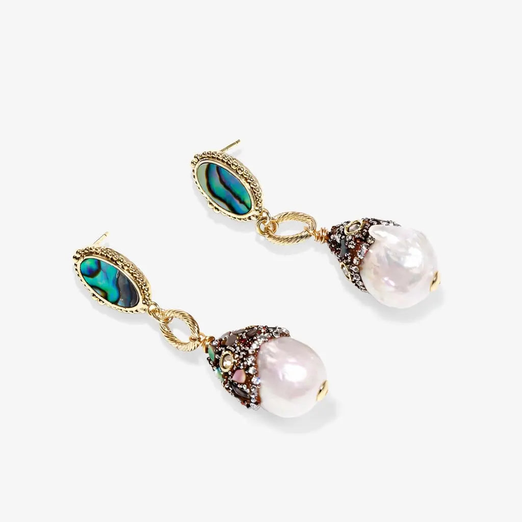 Baroque pearl drop earrings with abalone accents and gold detailing on white background