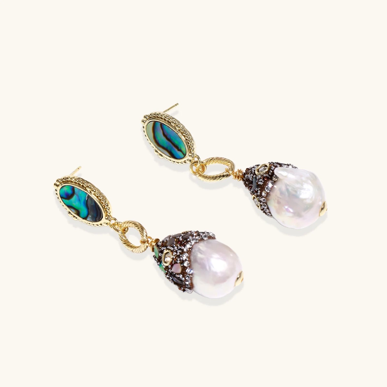 Pair of earrings with pearls and gemstones on a white background