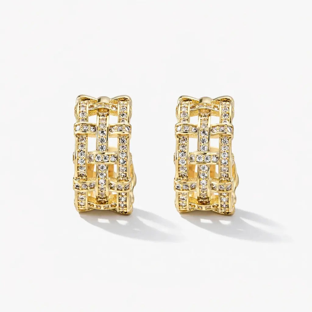 Pair of gold lattice hoop earrings with sparkling crystal accents on white background