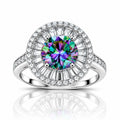 A radiant halo ring featuring a large round-cut iridescent center stone with a silver-toned pavé setting and a halo of clear baguette and round diamonds, shown on a white background with a reflection below.