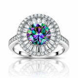A radiant halo ring featuring a large round-cut iridescent center stone with a silver-toned pavé setting and a halo of clear baguette and round diamonds, shown on a white background with a reflection below.