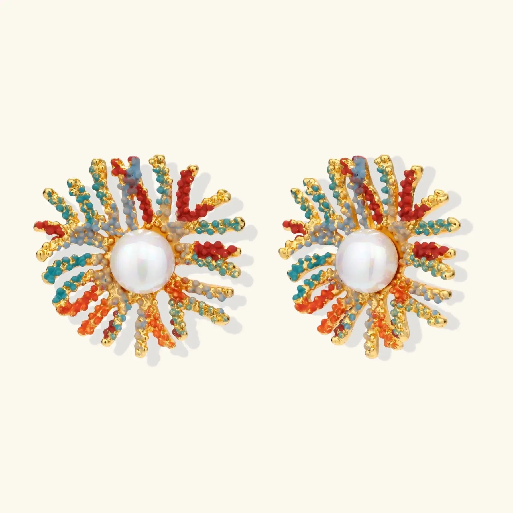 Pair of colorful sunburst earrings with pearl center on a white background