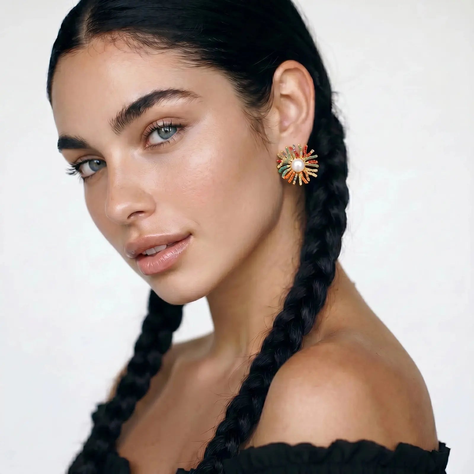 Woman wearing colorful earrings with a white background