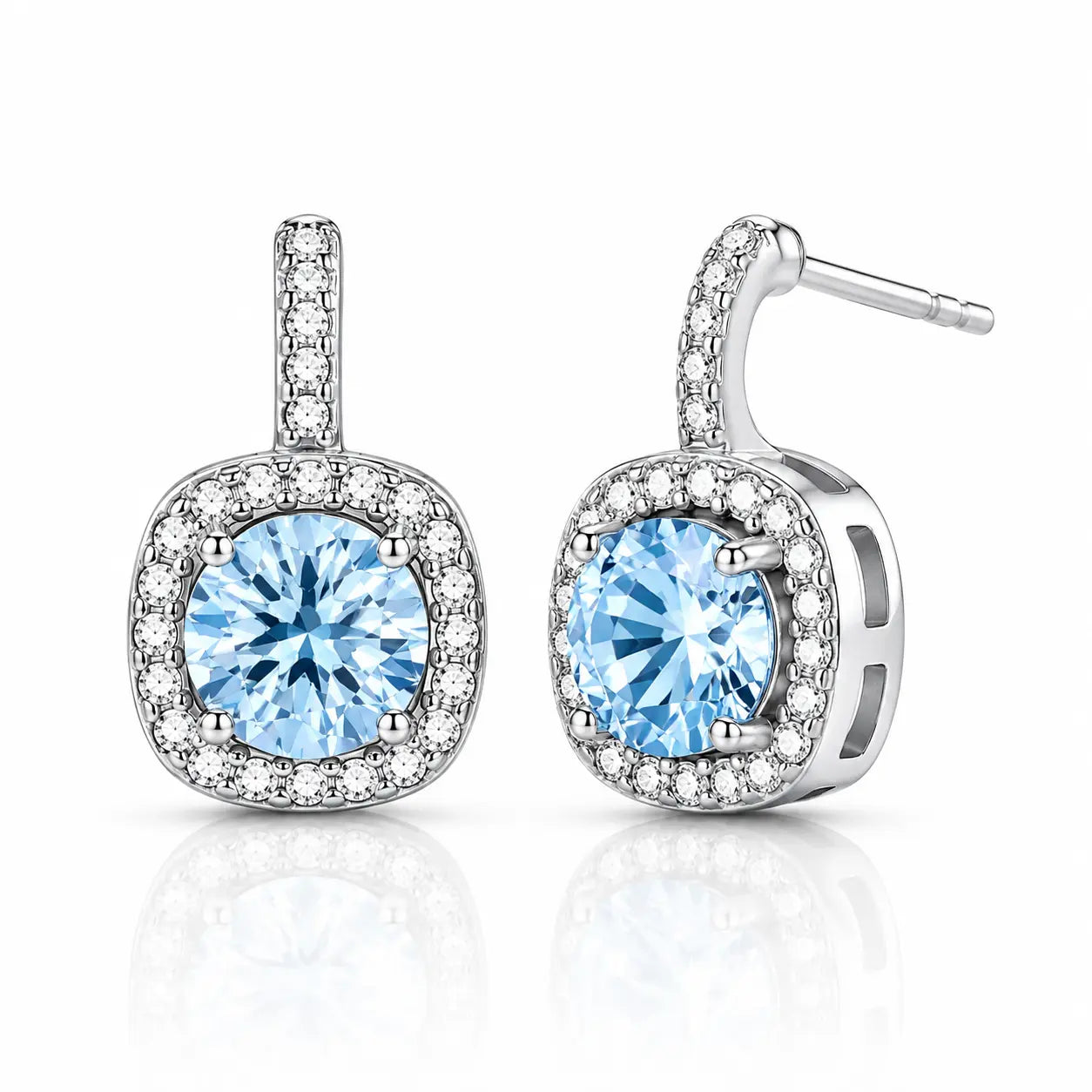 A pair of silver-toned drop earrings featuring a large round-cut light blue gemstone in a halo setting, with smaller clear stones along the top bar and around the square-shaped drop, shown on a white background with a soft reflection.