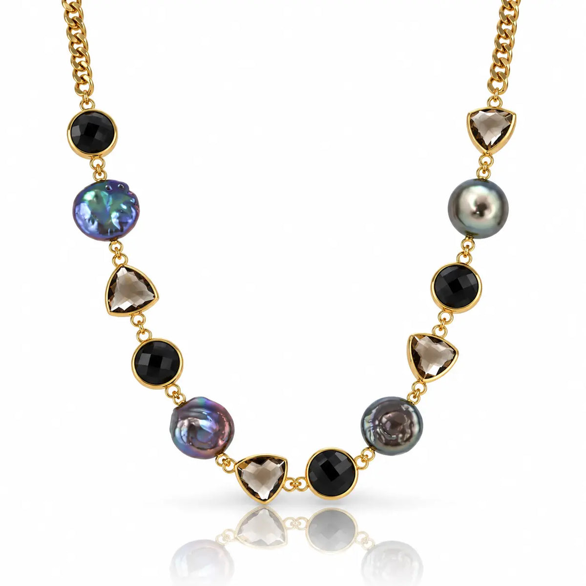 A gold chain necklace featuring alternating round black onyx beads, faceted smoky quartz triangle beads, and irregular iridescent pearl beads in gold settings, displayed on a clean white background with a soft reflection.