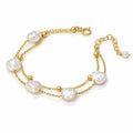 A double-strand gold chain bracelet featuring irregular white baroque pearls and small gold beads, displayed on a clean white background.