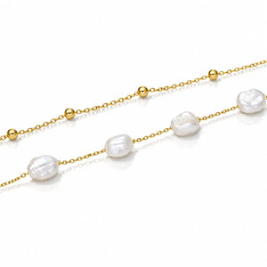 A delicate gold chain necklace featuring irregular white baroque pearls and small polished gold beads, displayed on a clean white background.