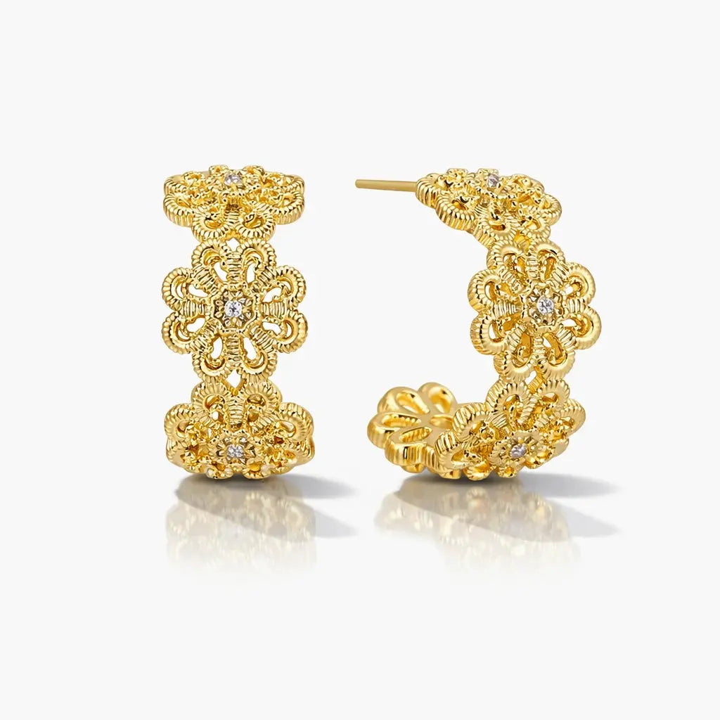 Gold filigree hoop earrings with floral design and embedded crystals, displayed on white background.