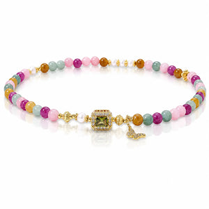 A multicolor beaded bracelet with gold-plated metal details, featuring a central green gemstone, a small white pearl, and a butterfly charm, displayed on a clean white background.
