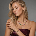 Woman wearing a colorful necklace and bracelet against a gray background