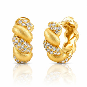 A pair of gold huggie hoop earrings with pavé diamond accents, shown from both the front and side angles on a reflective white surface. The side view shows a 'S925' sterling silver mark on the inside.