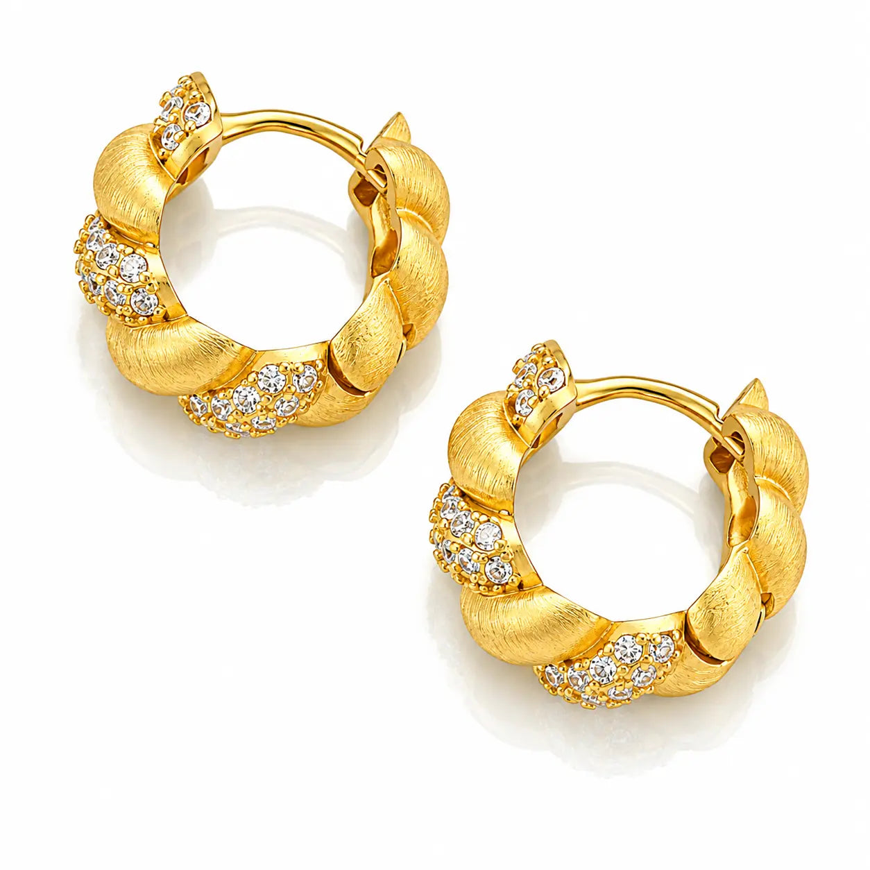 A pair of gold huggie hoop earrings with textured twisted bands and rows of small clear pavé stones, shown on a clean white background.