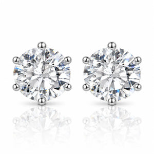 A pair of round-cut diamond stud earrings in a six-prong setting, shown on a clean white background with soft reflections below.