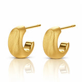 A pair of textured gold huggie hoop earrings with post backs, displayed on a clean white background with soft reflections below.