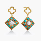Pair of gold earrings with turquoise accents and a central pearl on a white background