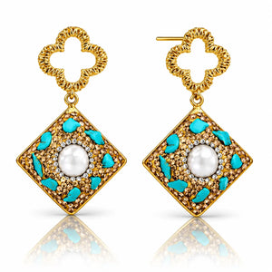 Pair of gold earrings with turquoise accents and a central pearl on a white background