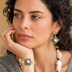 Woman wearing elegant earrings and rings against a natural background