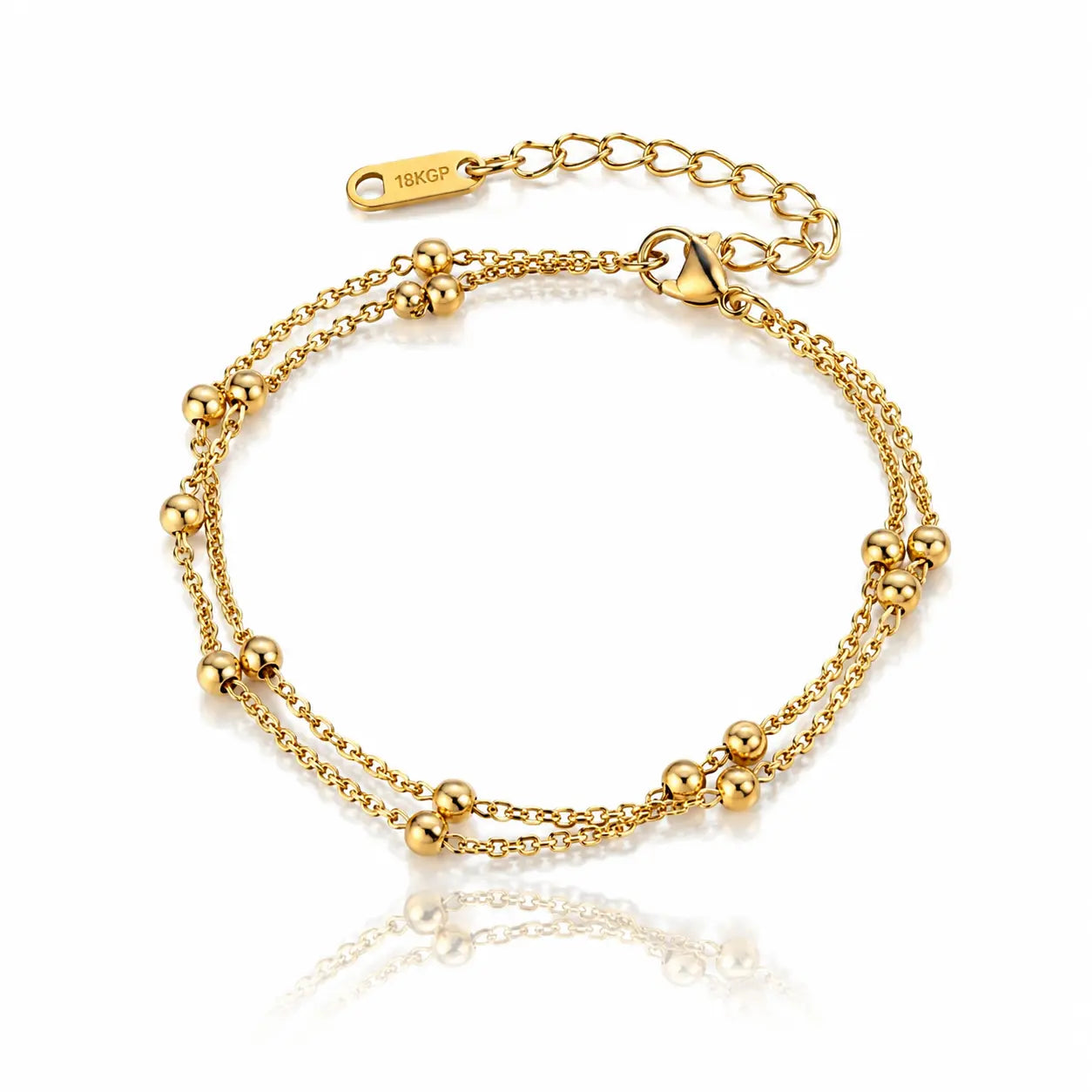 A gold double-strand chain bracelet with small polished bead accents and an adjustable lobster clasp, shown on a clean white background with a soft reflection below.