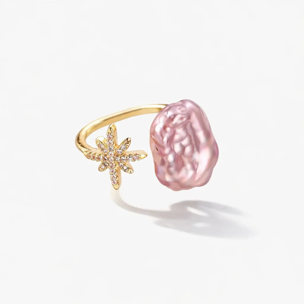 Gold ring with pink baroque pearl and crystal starburst design on white background