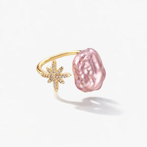 Gold ring with pink baroque pearl and crystal starburst design on white background