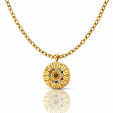 Gold necklace with a circular pendant featuring colorful stones on a white background