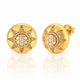 A pair of round yellow gold stud earrings with a starburst design paved with clear gemstones, shown on a reflective white surface.