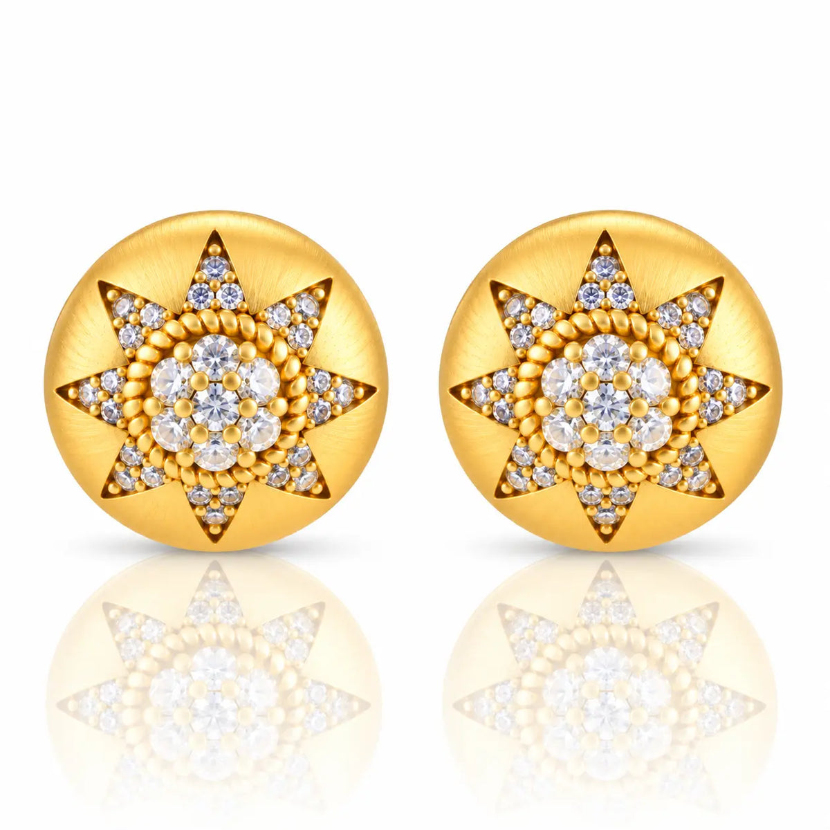 A pair of round gold starburst stud earrings set with clear gemstones, displayed on a clean white background with a soft reflection below.